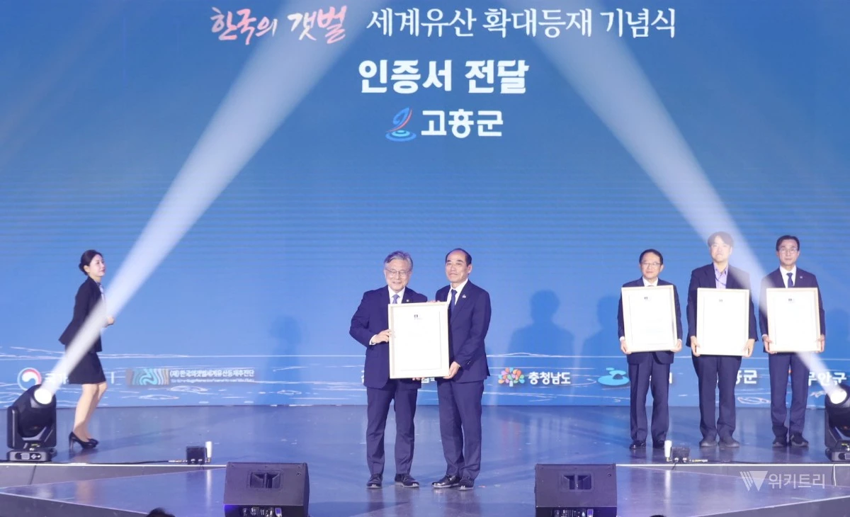 양국진 고흥부군수(오른쪽)가 허민 국가유산청장(왼쪽)으로부터 고흥갯벌의 유네스코 세계유산 등재 인증서를 전달받고 기념촬영을 하고 있다 / 고흥군
